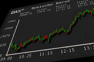Close-up of a German DAX stock index chart on a digital display, showing candlestick price movements and market data.